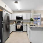 2-BR Apartments in Palm Bay FL - Meri Palm Bay - Kitchen with White Cabinets, Granite-Style Countertops, Tile Flooring and Stainless Steel Appliances.